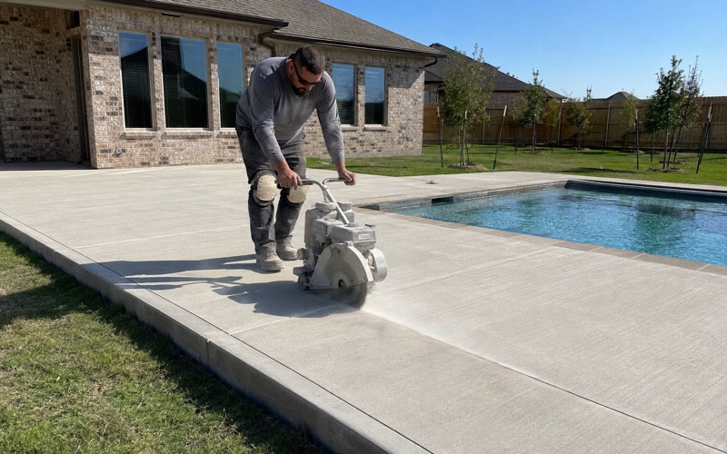 Concrete being placed from a buggy into a formed right of way sidewalk in Kyle, the forms and the drive approach running away behind it.